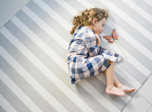 little girl laying on bumpa mat grey stripe lifestyle 